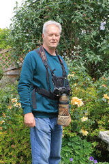 This is the harness I use when walking. The camera has a small attachment on its base which lets it slip securely into the groove on the front of the harness. There is no weight on my neck from the camera strap. It does not need to be on as there are safety straps on the harness